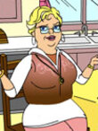 A blonde woman in a sweatsuit sits at her kitchen table.
