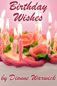 A lovely birthday cake, covered with pink frosting roses, and lit pink birthday candles.