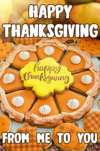 A plate of dcookies made to look like pie slices, with a decorative cookie in the middle that says Happy Thanksgiving. 