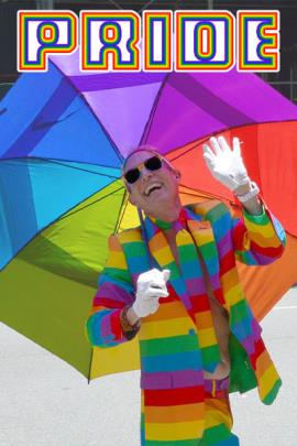 A man holding a rainbow umbrella and wearing a rainbow striped jacket and tie while wearing sunglasses, white gloves and tilting his head back to smile and laugh. Above him in a rainbow font is the word, "Pride" for LGBTQ Pride.