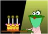 A frog sits at a table set with a birthday cake, and piled with presents.