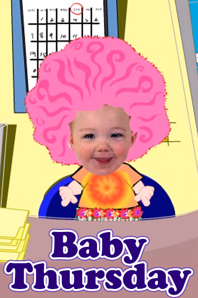 A baby with pink hair sits at a desk in an office.