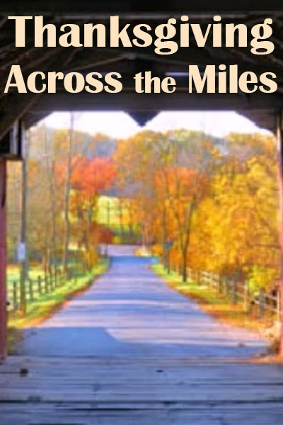 A long dirt lane, flanked by split rail fences, and colorful autumn trees.