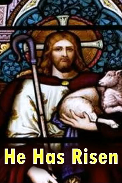 A stained glass window depicting jesus. He is holding a shepherd's crook in one hand, and cradling a lamb with the other.