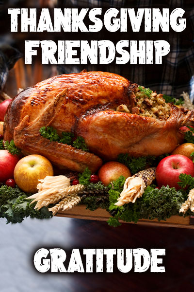 A huge, oven-roasted turkey on a platter decorated with greenery, and red apples.