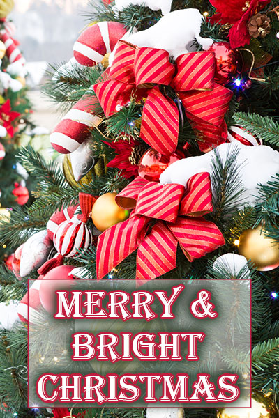 A Christmas tree, heavily decorated with bows, candy canes, ornaments, and snow. Merry and Bright Christmas is written at the bottom of the image.