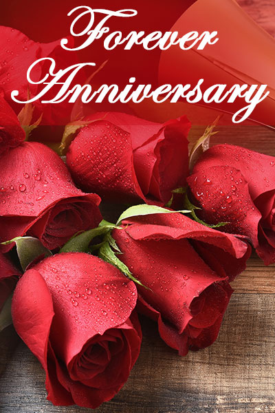 A bouquet of red roses rests on a wooden table.