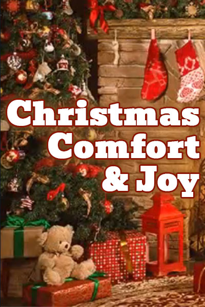 A beautifully decorated Christmas tree, with presents and toys underneath, sits next to a fireplace with stockings hung on the mantle. Christmas Comfort and Joy is written next to it.