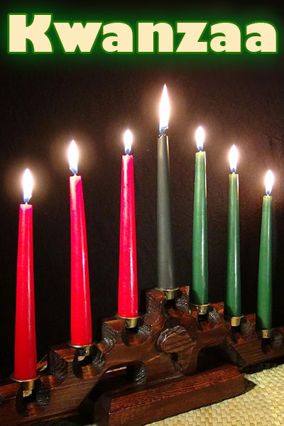 A beautiful carved wood kinara, with seven lit candles. The ecard title Kwanzaa is above.