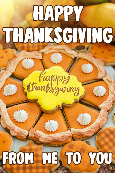 A plate of dcookies made to look like pie slices, with a decorative cookie in the middle that says Happy Thanksgiving. 