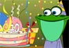 A lizard seated at a table, smiling at the birthday cake and presents next to it. 