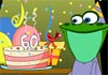 A lizard seated at a table, smiling at the birthday cake and presents next to it. 