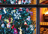 The viewer is looking through a window into a room with a festive Christmas tree in it. There are presents under the tree, and a cozy fire burning in the fireplace. The ecard title Christmas Spirits appears at the top.