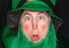 A man dressed as a leprechaun, with a green beard and top hat. He looks surprised.